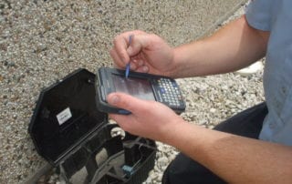 Copesan technician completing documentation on a handheld device.