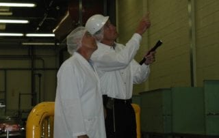 Pest control professional inspecting a warehouse with a client.